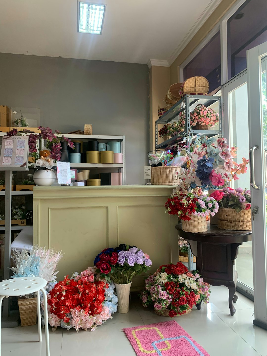 Färgglada konstgjorda blomsterarrangemang utställda i en butik.